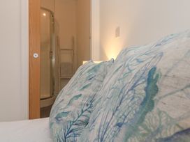 A bedroom with a bed and a shower visible in Upper Deck Truro