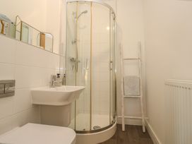 A bathroom with a shower, sink, and toilet at Upper Deck in Truro