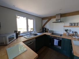 A kitchen with sink, oven, and appliances at Roman Lodge in Osmington