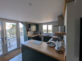 A kitchen with a sink and microwave at Roman Lodge in Osmington