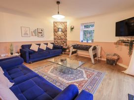 A living room with blue sofas and a foosball table at 8 Beechwood Close in Bowness-On-Windermere