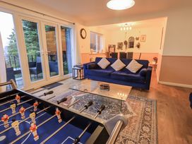 A living room with a sofa and foosball table at 8 Beechwood Close Bowness-On-Windermere