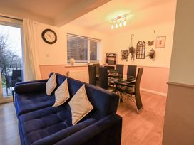 A dining room with a sofa and dining table at 8 Beechwood Close in Bowness-On-Windermere