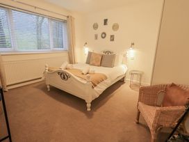 A bedroom with a bed and a chair at 8 Beechwood Close Bowness-On-Windermere