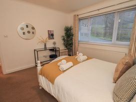 A bedroom with a bed and desk at 8 Beechwood Close in Bowness-On-Windermere