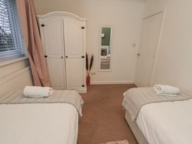 A bedroom with two beds and a wardrobe at 8 Beechwood Close Bowness-On-Windermere