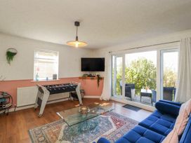 A living room with a foosball table and television at Lake View in Bowness-On-Windermere