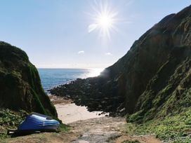 A beach scene with rocks and a boat at Higher Roskestal in St. Levan near Porthgwarra