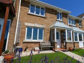 A house exterior with a front door and windows at Cove Cottage in Weymouth