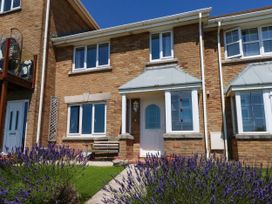 A house facade with a front door and windows at Cove Cottage in Weymouth