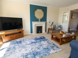 A living room with a television and coffee table at Cove Cottage in Weymouth