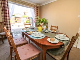 A dining room with a table set for a meal at Cove Cottage in Weymouth