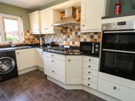 A kitchen with appliances and cabinets at Cove Cottage Weymouth