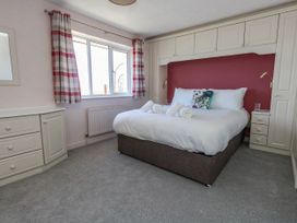 A bedroom with a bed and storage furniture at Cove Cottage in Weymouth