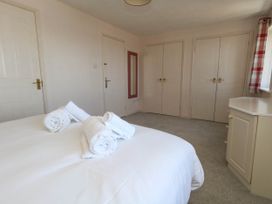 A bedroom with a bed and towels at Cove Cottage in Weymouth