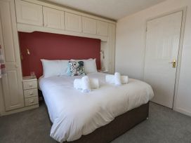 A bedroom with a bed and bedside cabinet at Cove Cottage in Weymouth