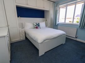 A bedroom with a bed and window at Cove Cottage in Weymouth