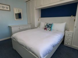 A bedroom with a bed and bedside tables at Cove Cottage in Weymouth