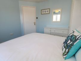 A bedroom with a bed and a chest of drawers at Cove Cottage in Weymouth