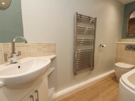 A bathroom with a sink, toilet, and towel rail at Cove Cottage in Weymouth