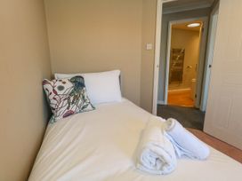 A bedroom with a single bed and towels at Cove Cottage in Weymouth