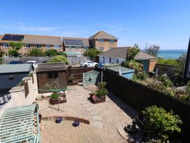 A garden with a shed, plants and pathway at Cove Cottage in Weymouth