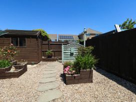 A garden with a pathway and shed at Cove Cottage in Weymouth
