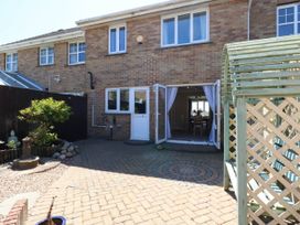 A garden with a patio and outdoor furniture at Cove Cottage in Weymouth