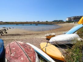 A beach with boats on the sand at Cove Cottage in Weymouth