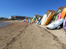 Surfboards and kayaks on a beach at Cove Cottage Weymouth