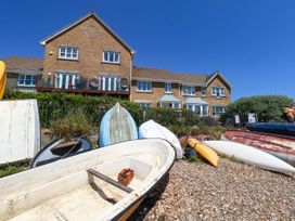 A building with boats on a pebbled area at Cove Cottage in Weymouth