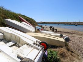 A beach with several boats on sand at Cove Cottage Weymouth