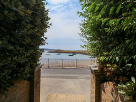 View of boats by the water from a pathway at Cove Cottage in Weymouth