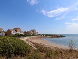 A beach with houses alongside at Cove Cottage in Weymouth