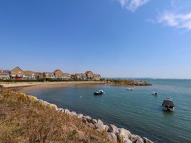 A beach with boats and houses at Cove Cottage Weymouth
