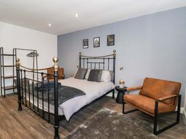 A bedroom with a bed and armchair at Chalet 2 East Heslerton near Sherburn