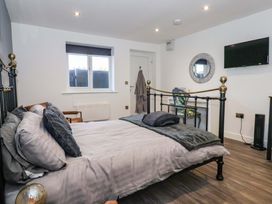 A bedroom with a bed and television at Chalet 2 in East Heslerton near Sherburn