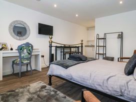 A bedroom with a bed, desk, and tv at Chalet 2 East Heslerton near Sherburn