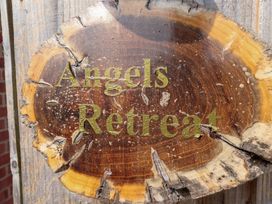 A wooden sign with the text Angels Retreat at Angel's Retreat in Huttoft