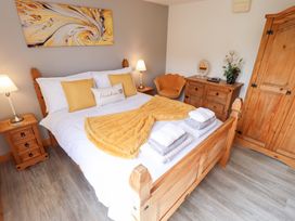 A bedroom with a bed and wooden furniture at Angel's Retreat in Huttoft
