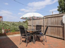A garden with a table and umbrella at Angel's Retreat in Huttoft