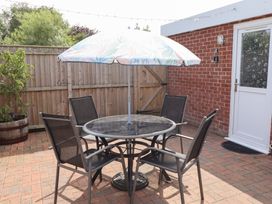 A garden with a table and chairs under an umbrella at Angel's Retreat in Huttoft