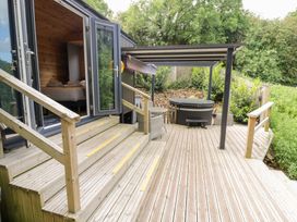 An outdoor area with steps leading to a hot tub at The Shepherds Hut at Bridge Lake Farm & Fishery, Chacombe