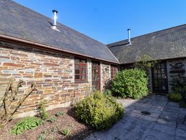An outdoor area with stone walls and greenery at Bracken Cottage St Tudy