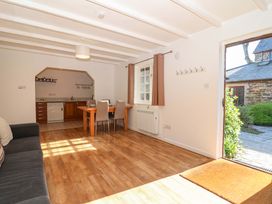 A living room with a kitchen area and seating at Bracken Cottage St Tudy