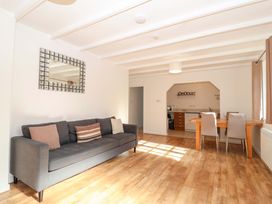 A living room with a sofa and dining area at Bracken Cottage St Tudy