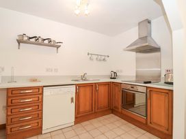 A kitchen with cabinets and appliances at Bracken Cottage St Tudy