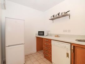 A kitchen with refrigerator, microwave, sink, and dishwasher at Bracken Cottage St Tudy