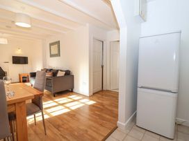 A living room with a refrigerator and dining area at Bracken Cottage St Tudy