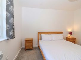 A bedroom with a bed and nightstands at Bracken Cottage St Tudy
